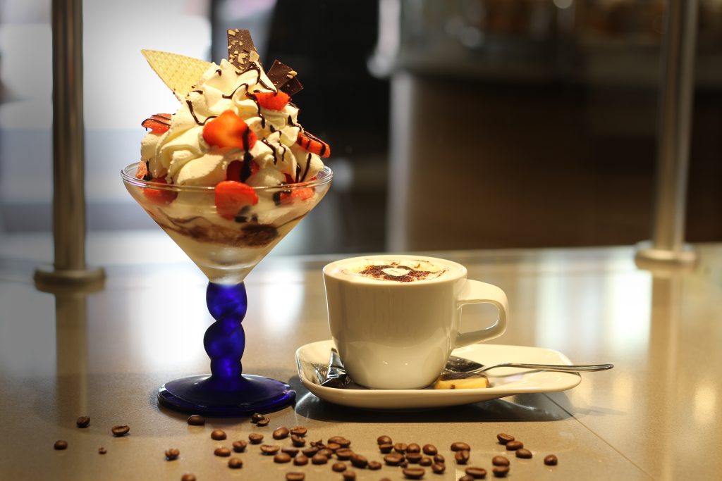 Erdbeer-Eisbecher mit einer Tasse Kaffee