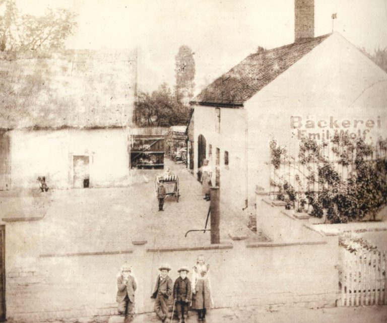 Historische Ansicht der Bäckerei Historische Straßenansicht mit Gebäuden und Personen der Bäckerei.
